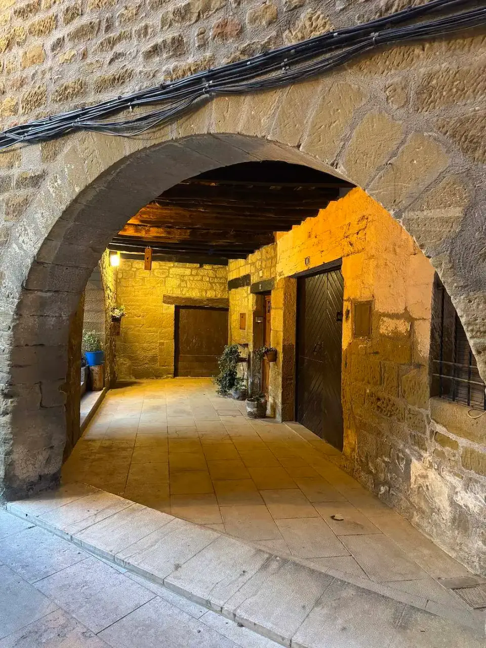 Pasaje con arco de piedra iluminado en el casco antiguo