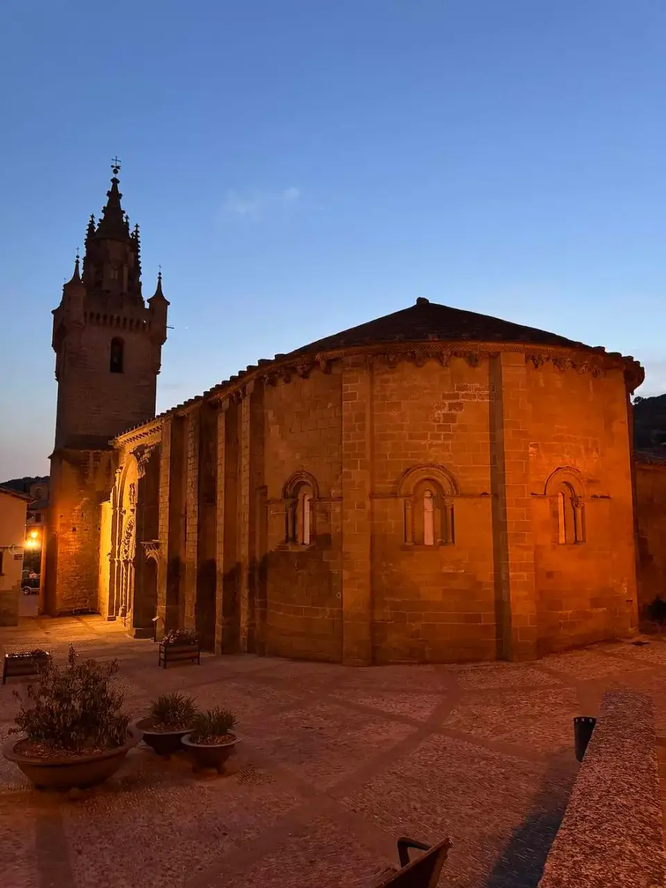 Ábside románico y torre de una iglesia al anochecer