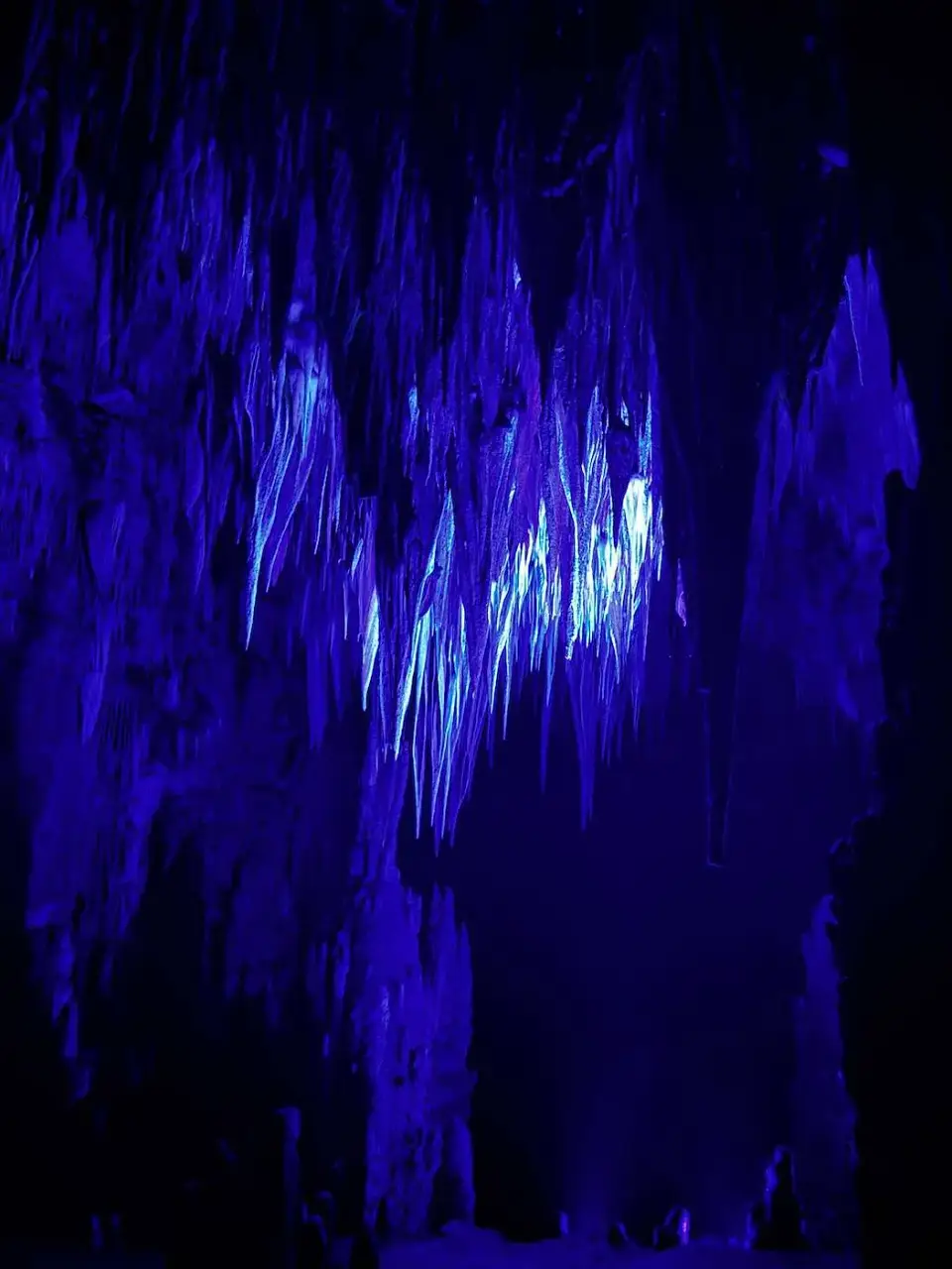 Estalactitas iluminadas con luz azul en la cueva