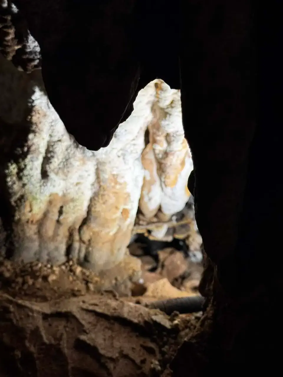 Formación de roca blanca iluminada en la oscuridad de la cueva