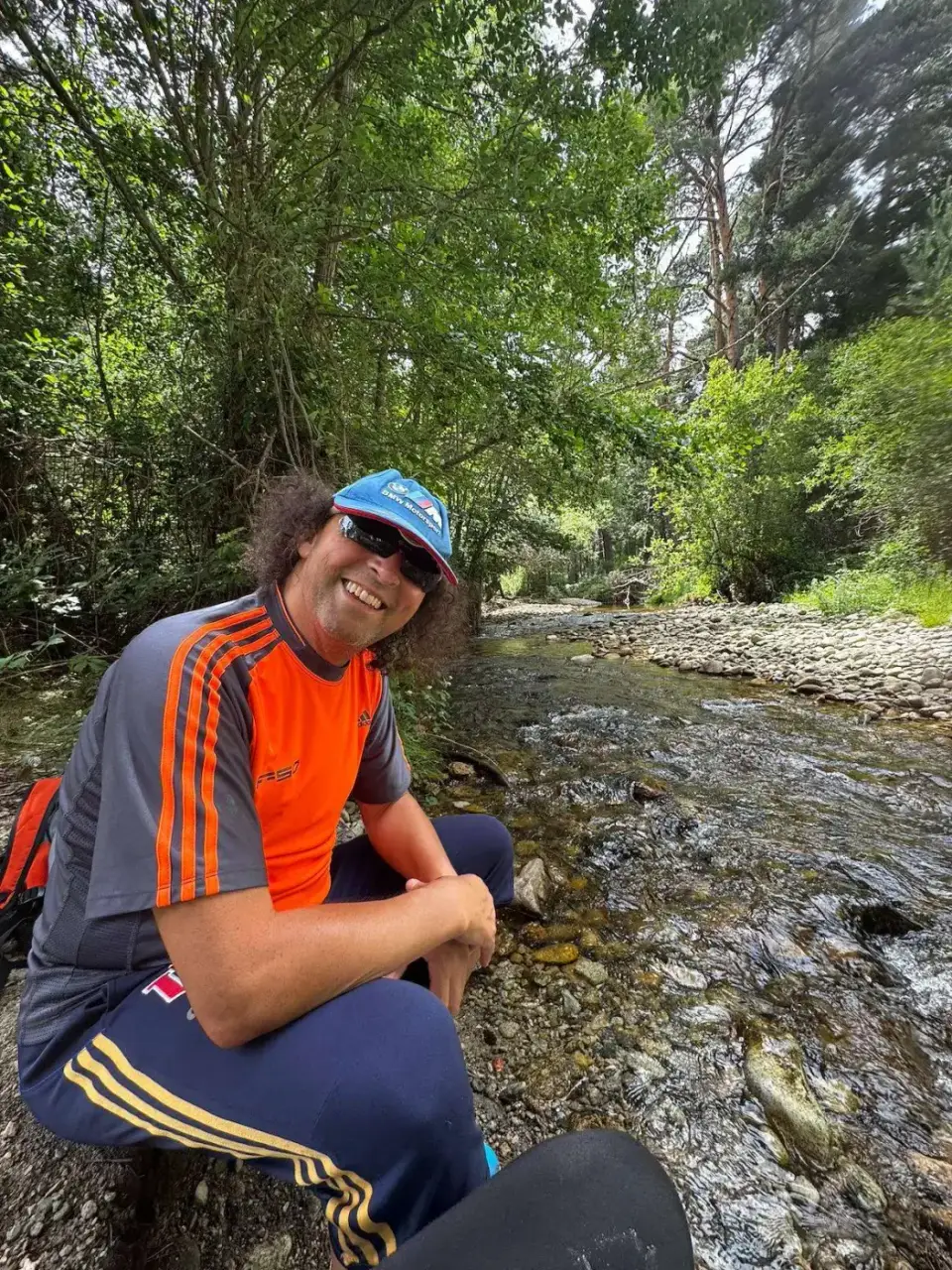 Jorge sentado junto a un arroyo del bosque