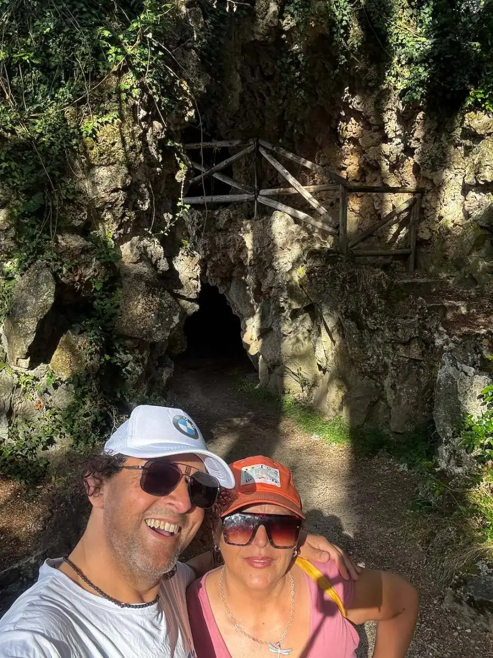 Jorge y Paola frente a una gruta cubierta de vegetación