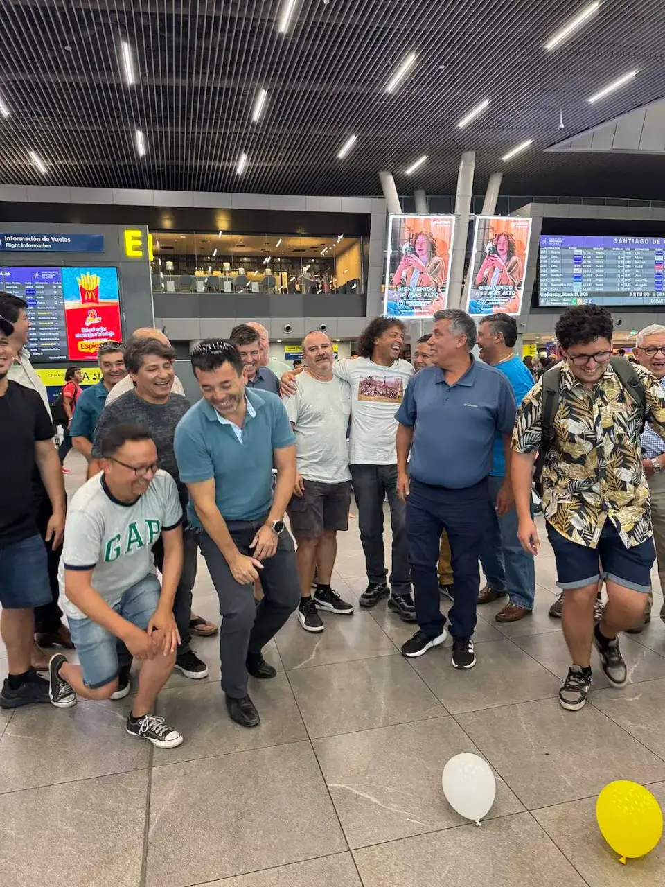 Amigos con globos despidiéndose en el aeropuerto
