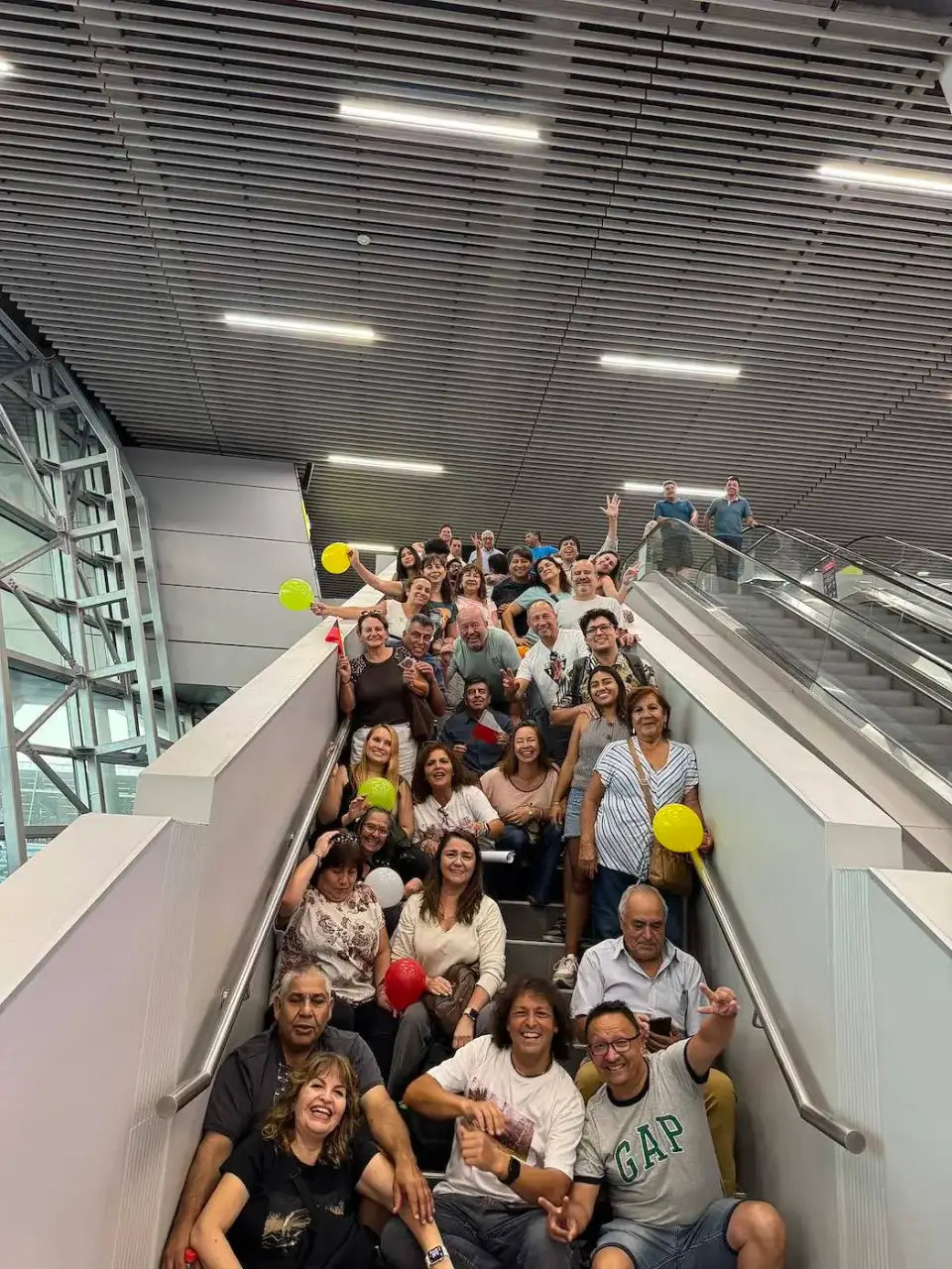 Familia y amigos reunidos en la escalera del aeropuerto