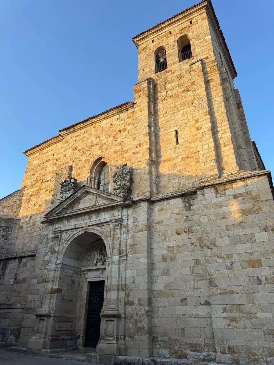 Iglesia románica de piedra dorada con su campanario